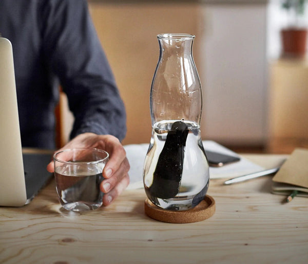 Personal carafe on table with active charcoal and cup